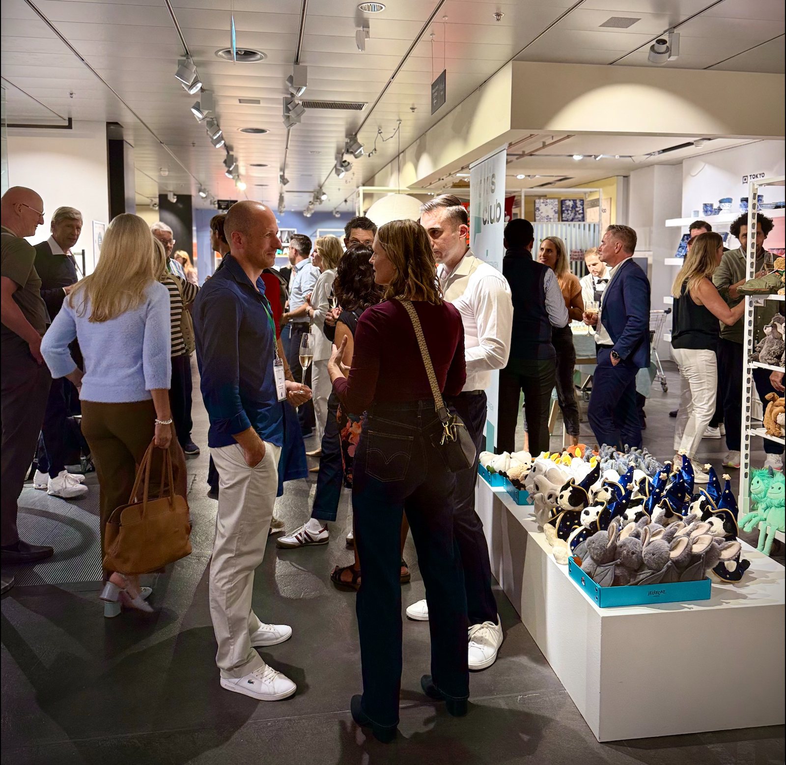 Viele Gäste im Gespräch zwischen den Regalen im Globus Luzern